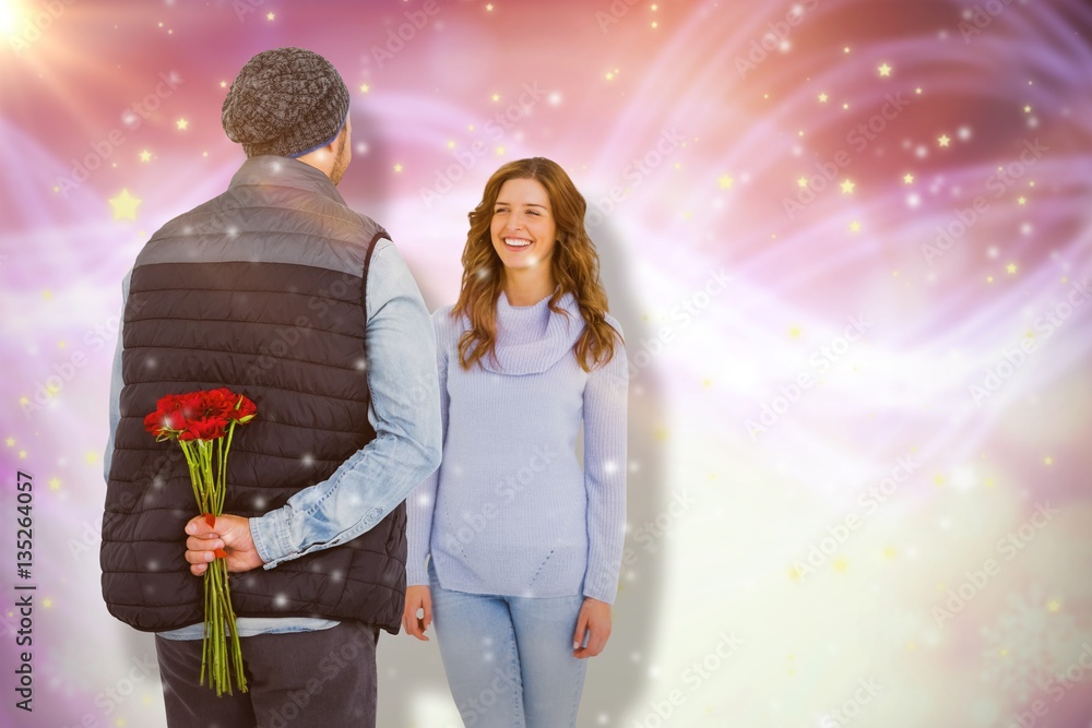 Composite image of man hiding roses behind back from woman