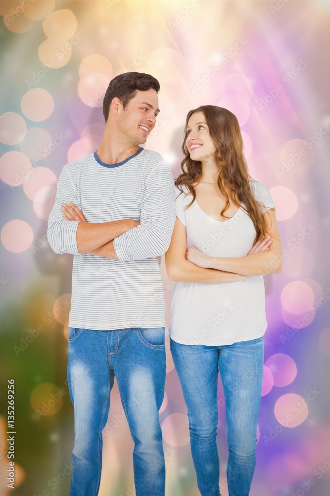 Composite image of happy couple standing with arms crossed