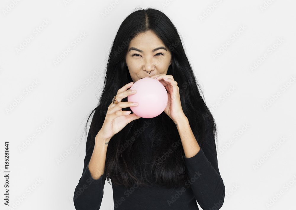 Young asian woman casual blowing a balloon