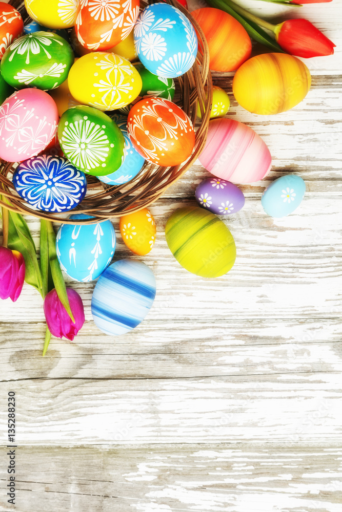 Easter eggs with tulips on wooden board