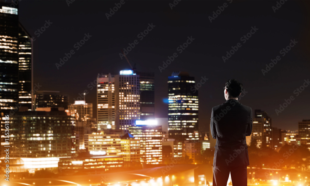 Businessman viewing night glowing city