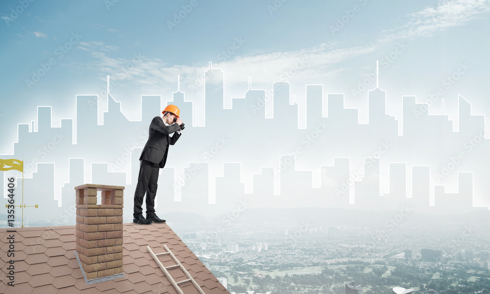 Engineer man standing on roof and looking in binoculars. Mixed media