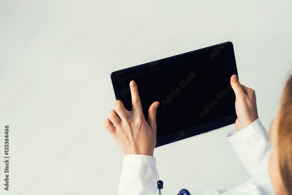 Close of female doctor hands working with tablet pc computer