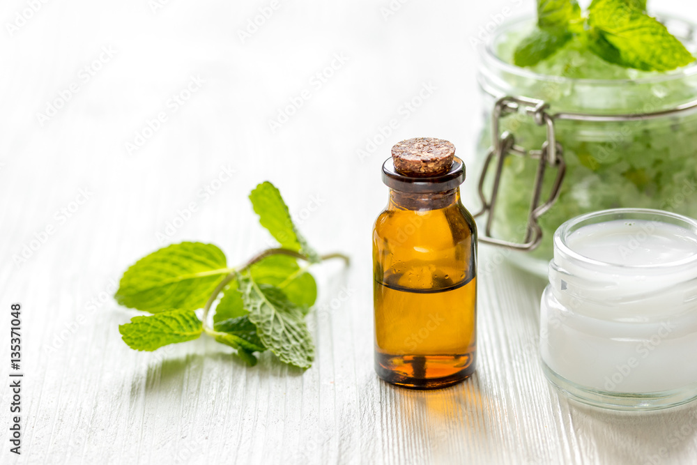 organic cosmetics with herbal extracts of mint on wooden background