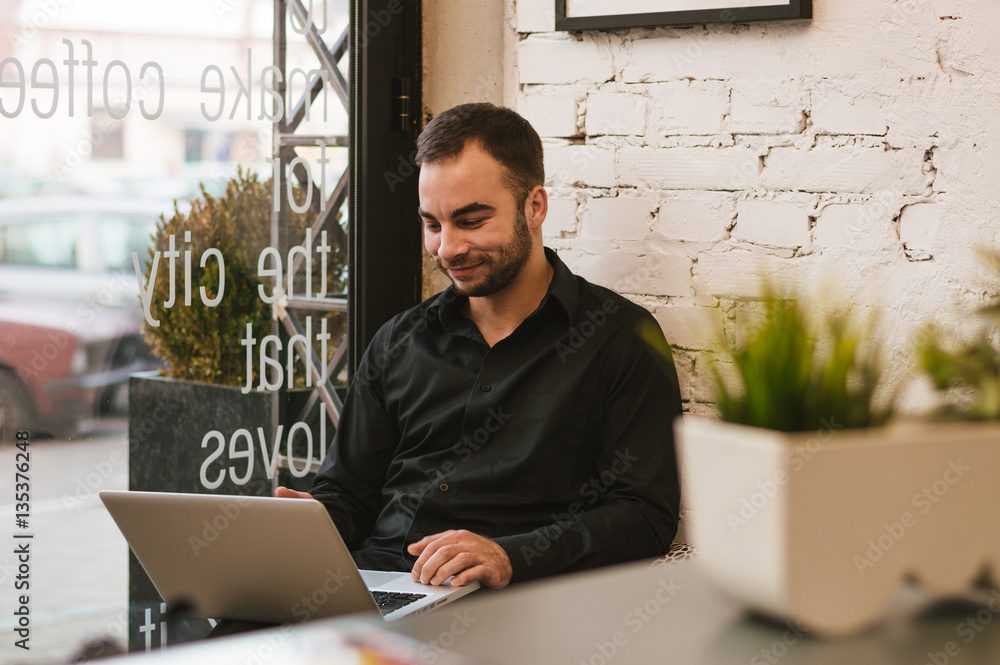 Handsome businessman in casual wear  is using a laptop working i