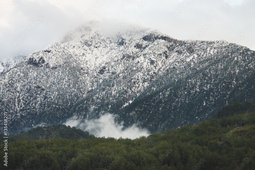 冬季，金牛座山脉的绿色斜坡被雪和云覆盖。土耳其南部，阿拉尼亚