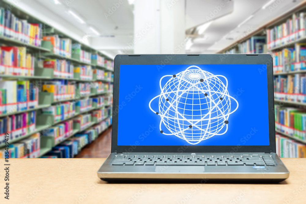 Laptop with blank screen on table with blur bookshelf at libraly