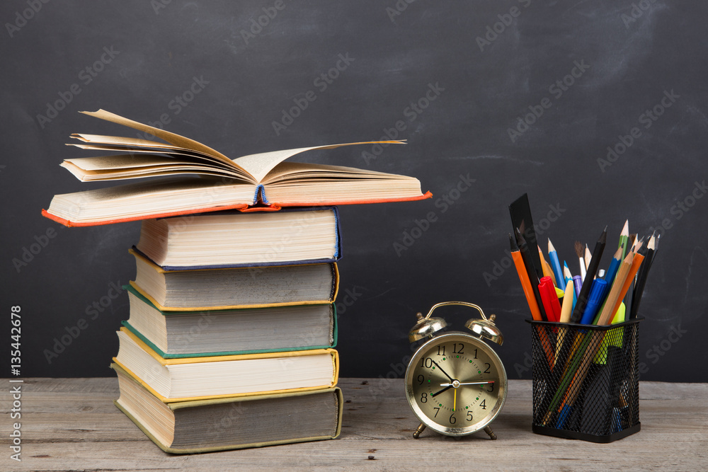 Education concept - books on the desk in the auditorium