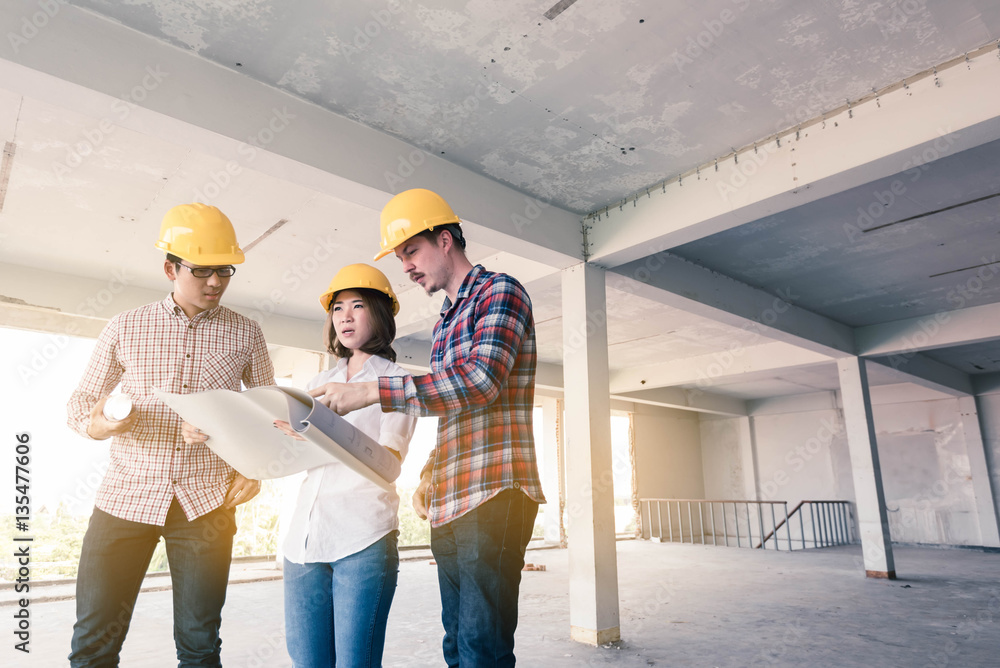 three construction engineers working together in side buiding pl