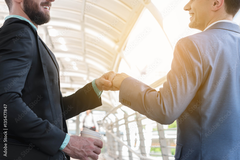 Two Westerner Business men talk and make fist bump on the public