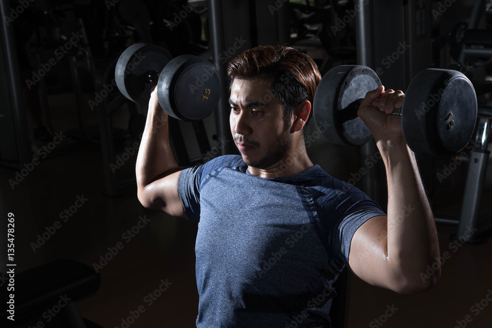 Man lift weight on shoulder press with studio light shot