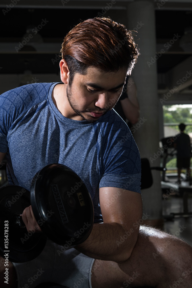 Man lift weight on arm press with studio light shot