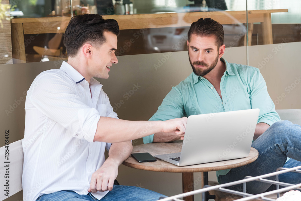 Two Westerner Business men working with laptop and smartphone to