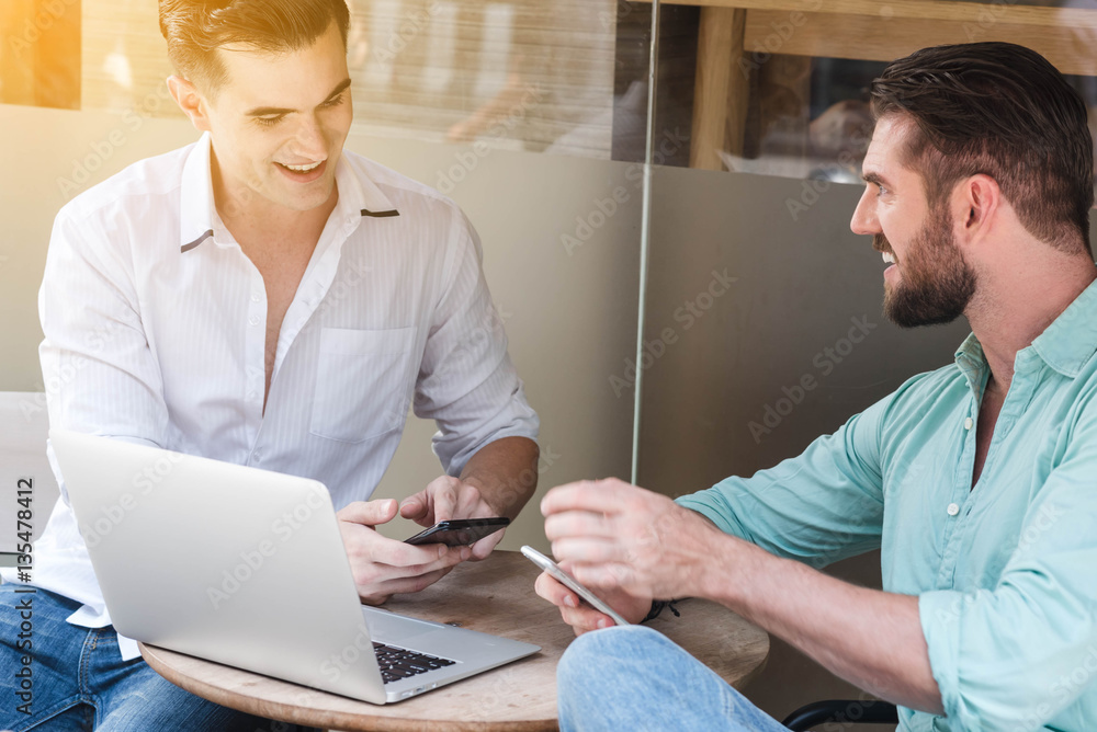 Two Westerner Business men working with laptop and smartphone to