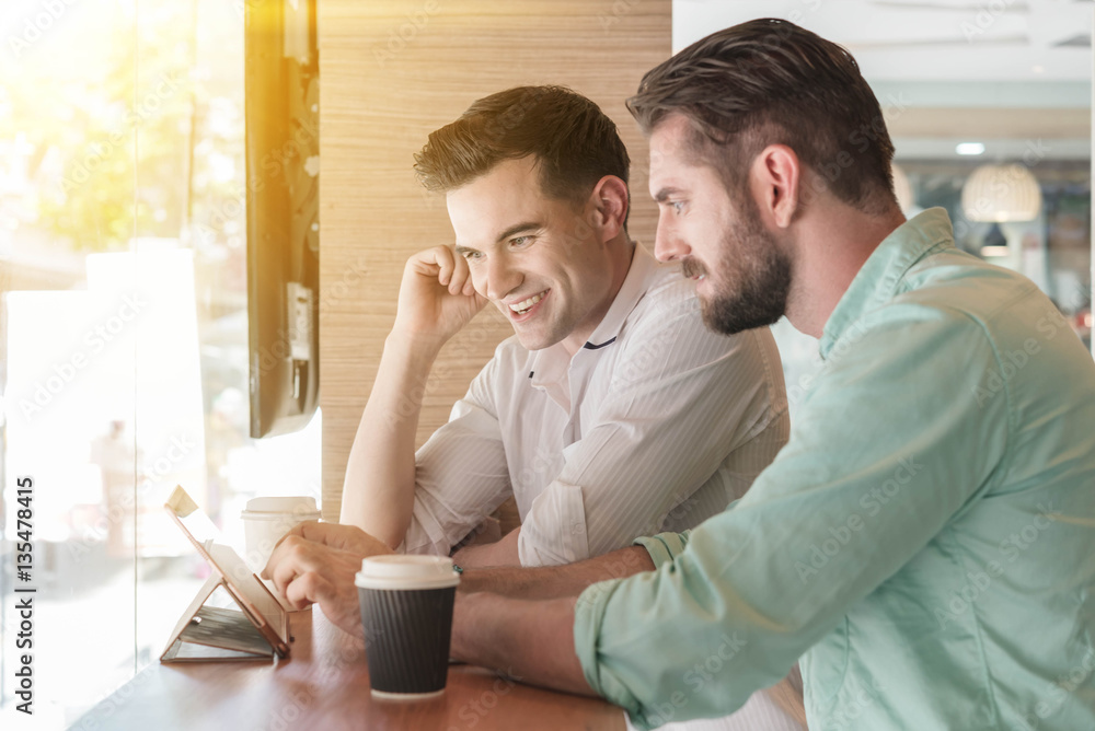 Two Westerner Business men working smartphone and tablet togethe