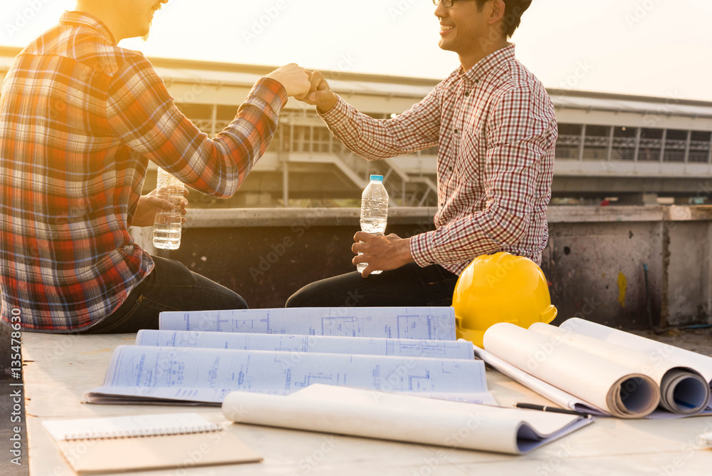 three construction engineers finished working make fist bump at