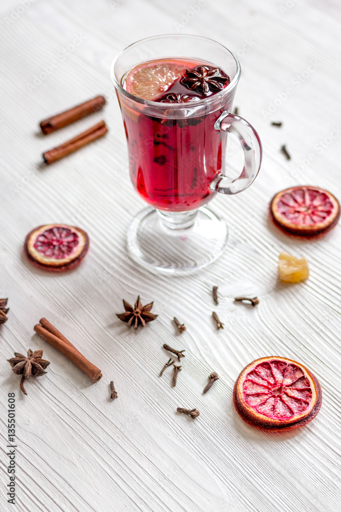 mulled wine with spices in cup on wooden background