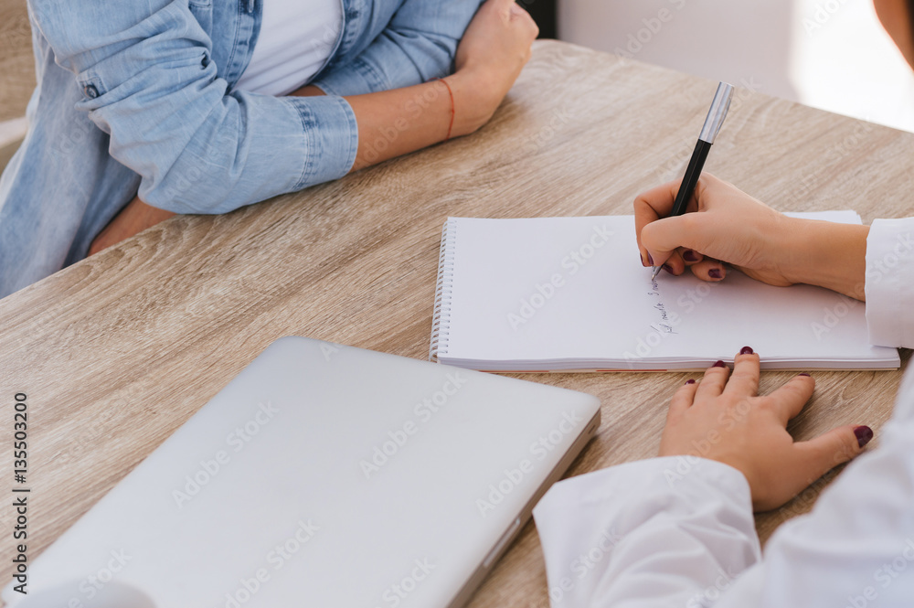 Doctor writing a prescription to a female patient