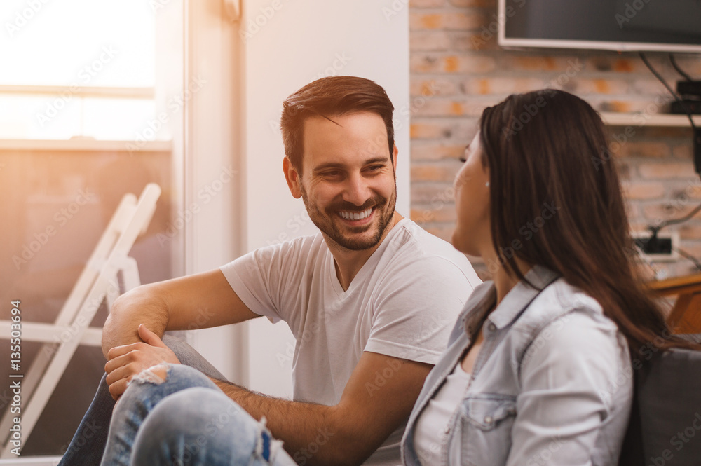 Beautiful couple at home talking, smiling, having a great time t