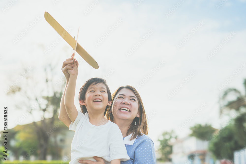 亚洲母子一起玩纸板飞机