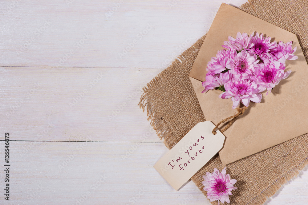 Valentines Day. Paper tag with brown envelope and pink flowers