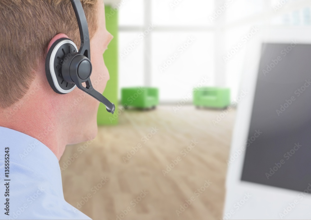 Man speaking on headphones in call centre