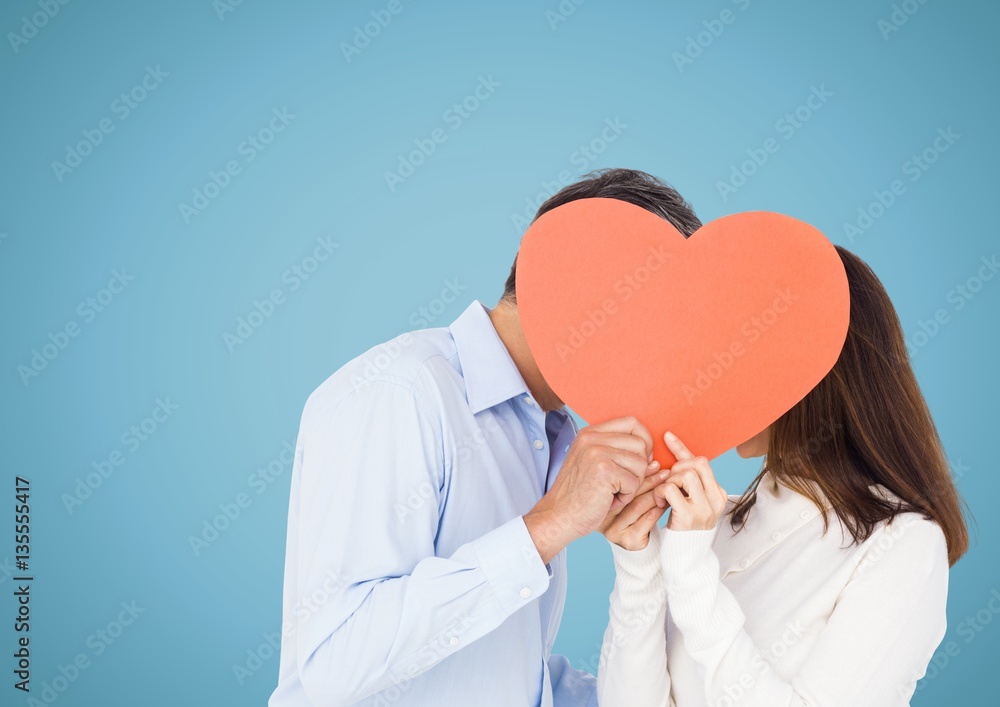 Romantic couple holding heart shape and kissing each other