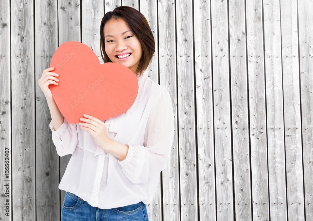 Happy woman holding a heart shape