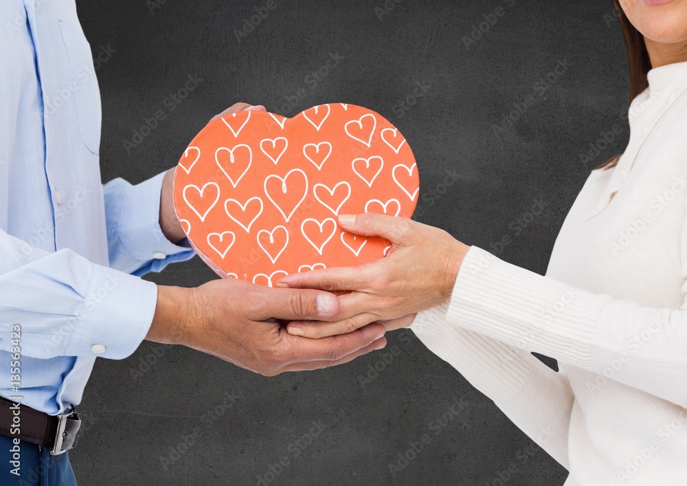 Couple holding heart shaped gift box