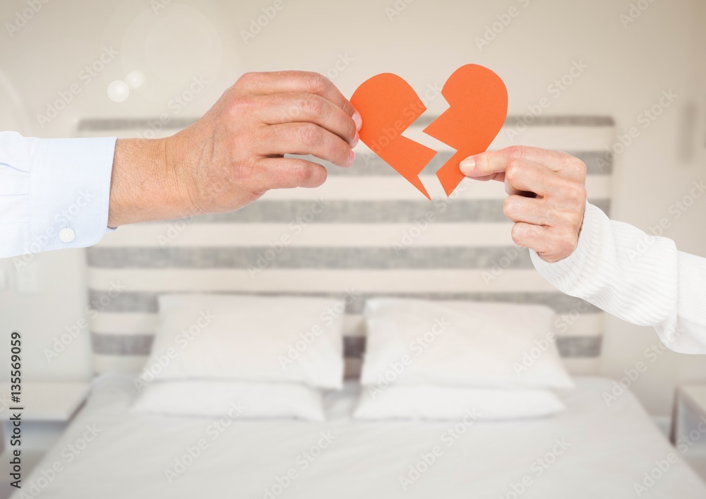 Hands of couple holding a broken heart in bedroom