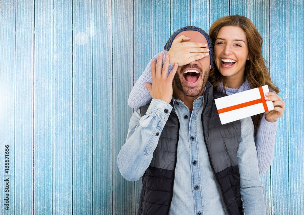 Woman giving surprise gift to man