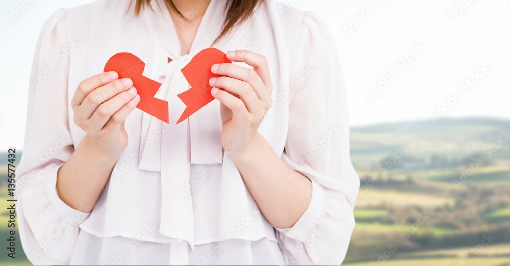 Mid-section of a woman holding a broken heart