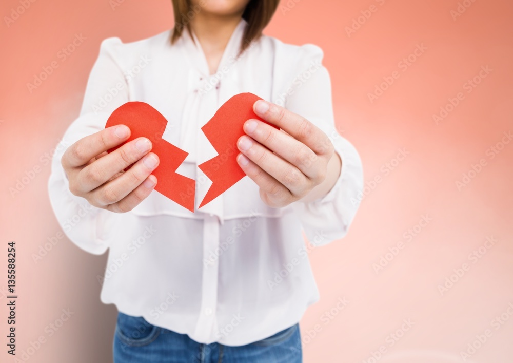 Mid-section of a woman holding a broken heart