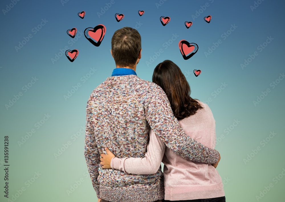 Rear view of couple standing with arms around