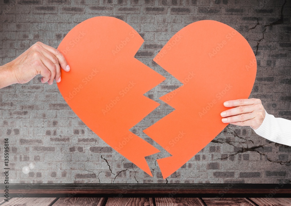 Hands of couple holding a broken heart