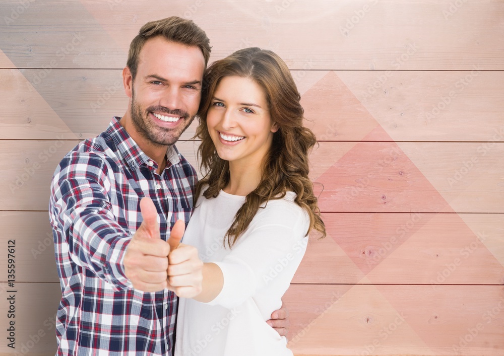 Couple showing thumbs up against wooden background