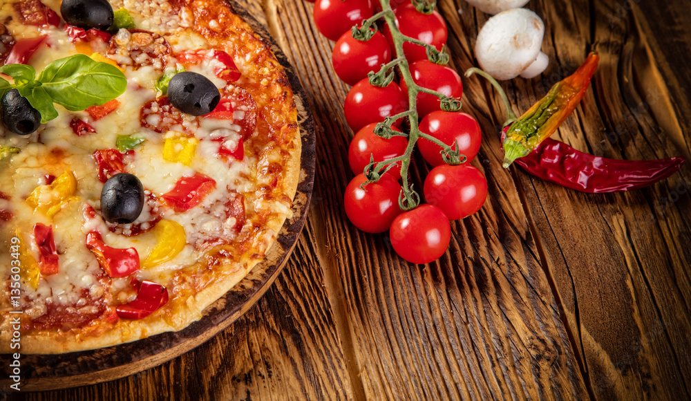 Pizza with ingredients served on wood