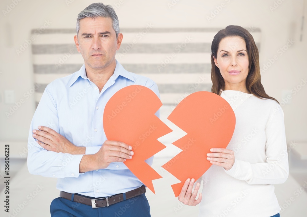 Composite image of couple holding broken heart