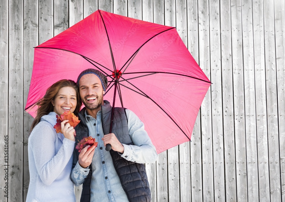 Couple with umbrella against wooden background