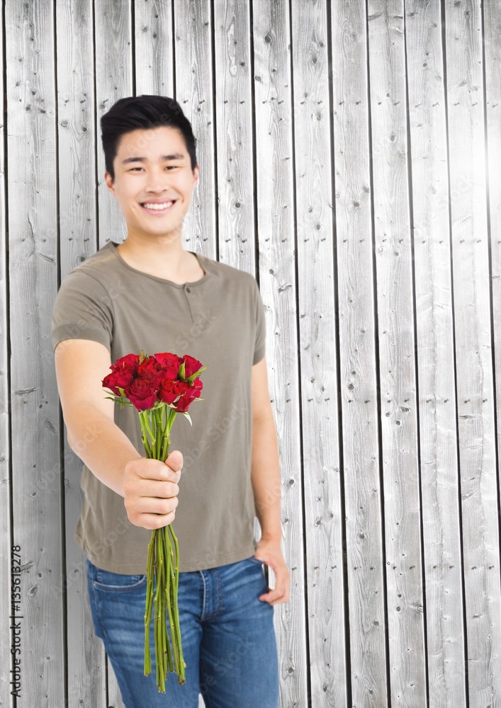 Smiling man holding bunch of flowers