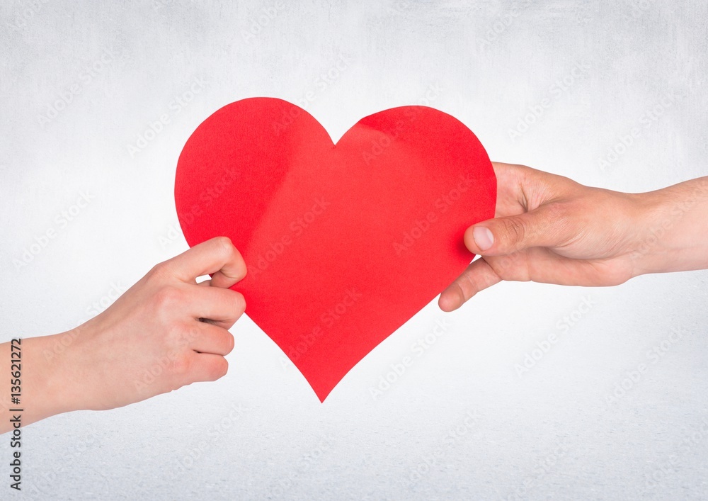 Hand of couple holding red heart