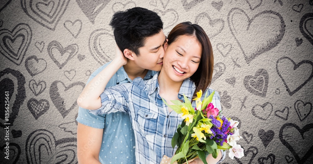 Man kissing woman while holding bouquet