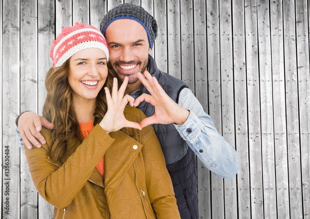 Portrait of happy couple forming a heart shape with hands