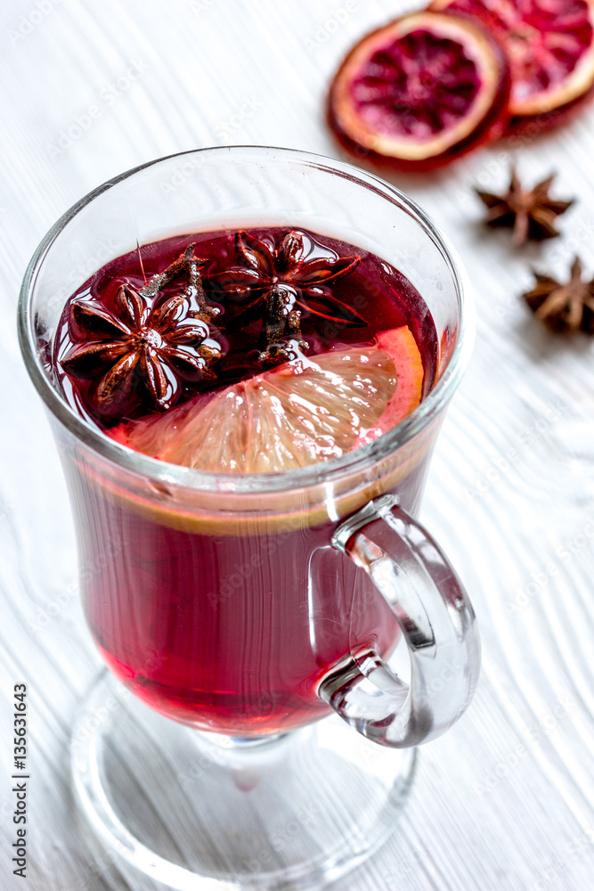 mulled wine with spices in cup on wooden background