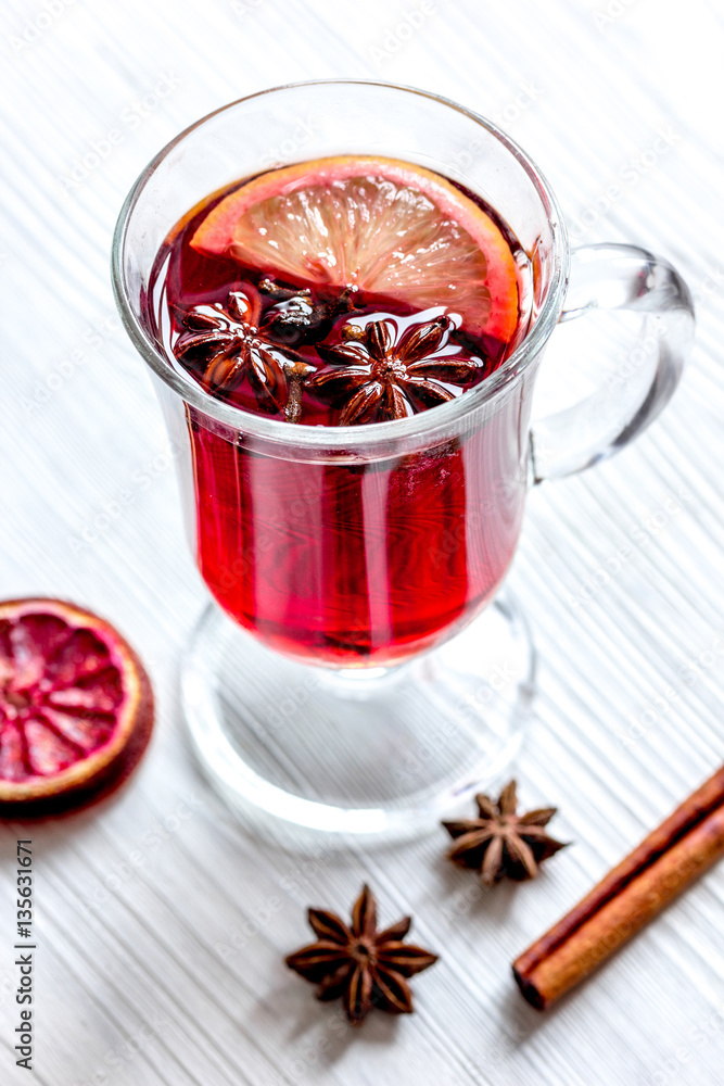 mulled wine with spices in cup on wooden background