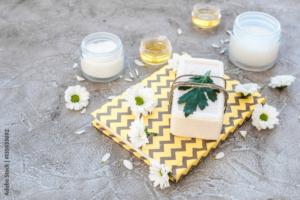 organic cosmetics with camomile on stone background