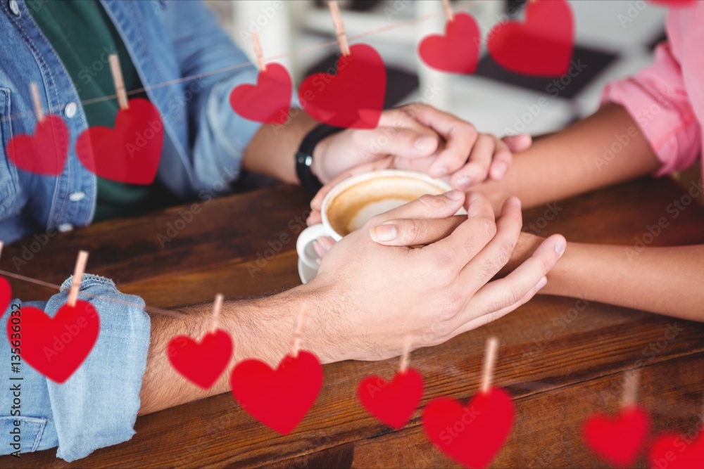 Romantic couple holding hands while having coffee