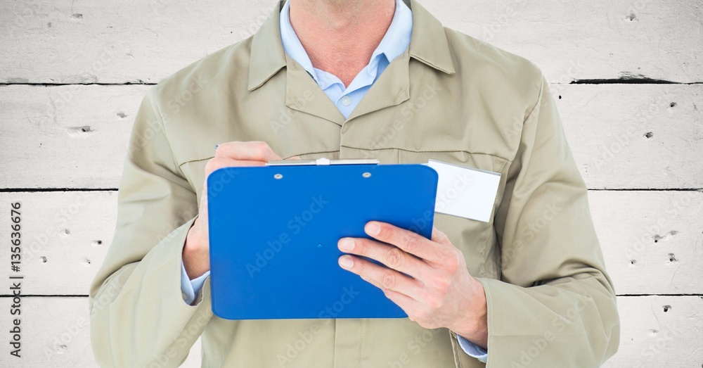 Mid section of male supervisor writing on clipboard