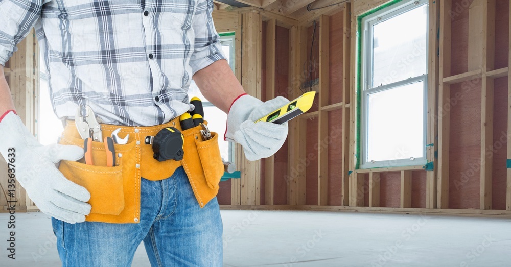 Mid section of handyman holding worktool