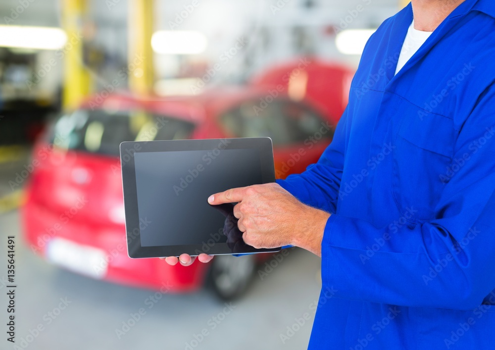 Mechanic using digital tablet in repair garage